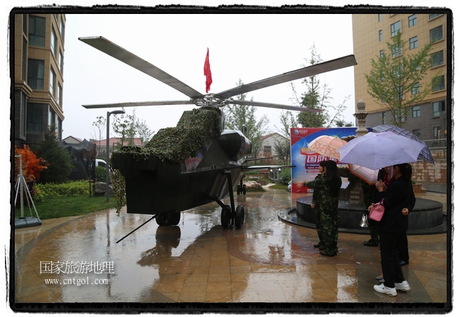 小區(qū)突然出現(xiàn)“飛機坦克”，其中殲15艦載戰(zhàn)斗機一架、99式主戰(zhàn)坦克一輛、武直-10武裝直升機一架，吸引了眾多市民雨中圍觀、合影。