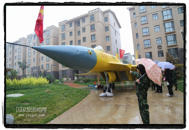 小區(qū)突然出現(xiàn)“飛機坦克”，其中殲15艦載戰(zhàn)斗機一架、99式主戰(zhàn)坦克一輛、武直-10武裝直升機一架，吸引了眾多市民雨中圍觀、合影。